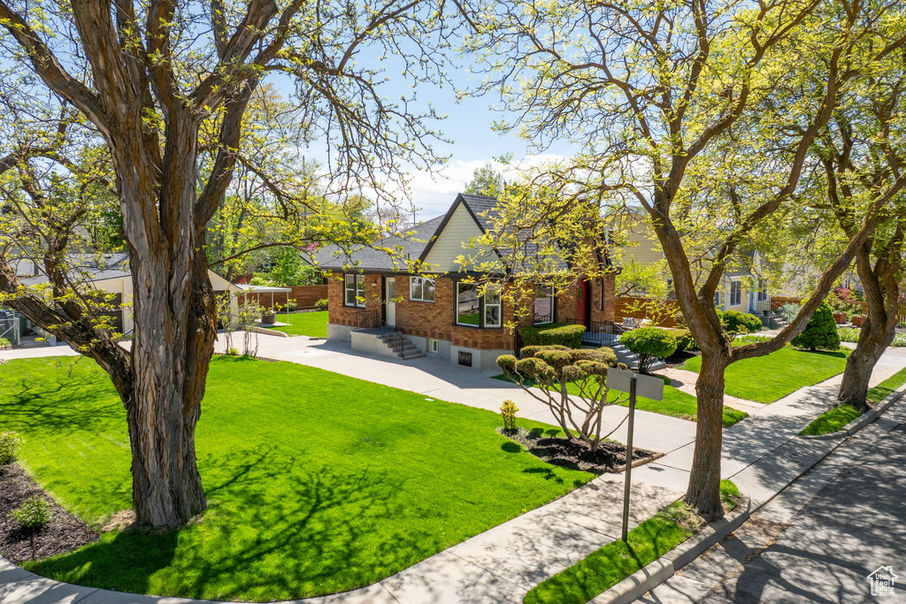 View of front of home with brick siding and a front lawn