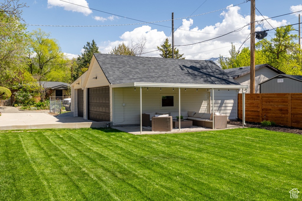Rear view of house featuring an outdoor hangout area, a shingled roof, and a patio area