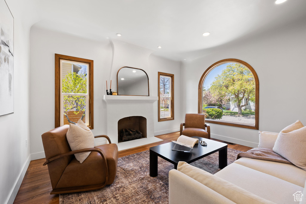 Living room with recessed lighting, baseboards, a fireplace, and wood finished floors