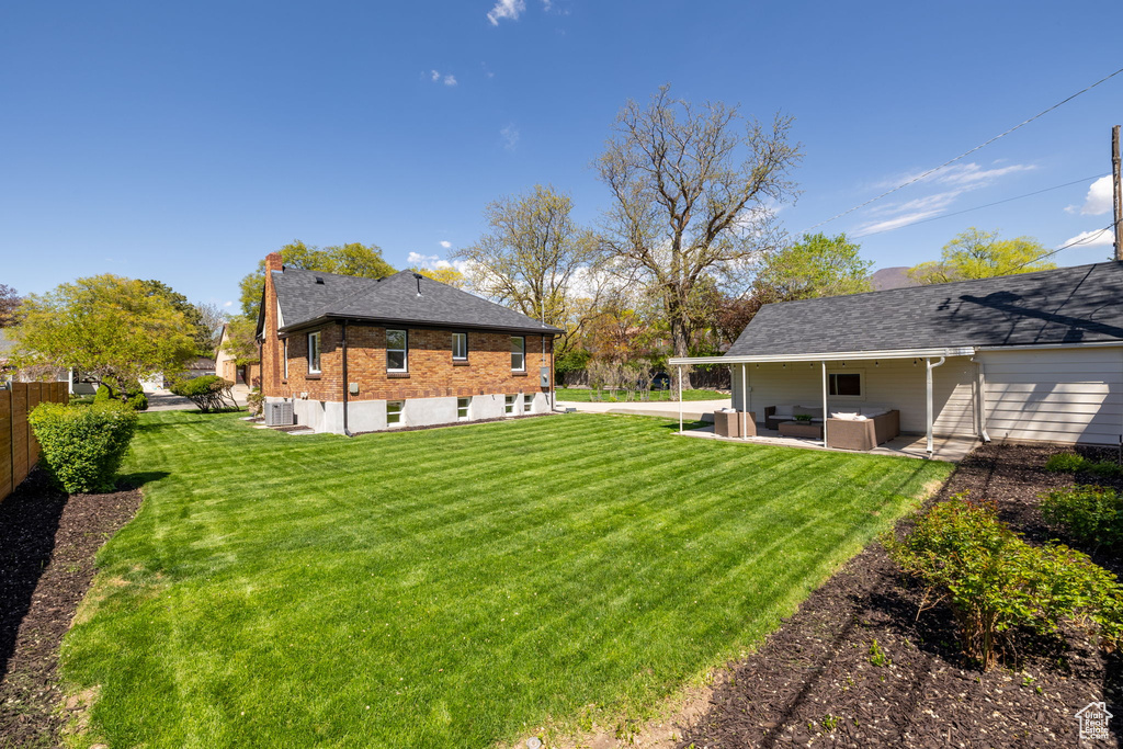 View of yard with an outdoor living space, a patio area, and cooling unit