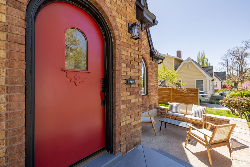 Entrance to property featuring brick siding and fence