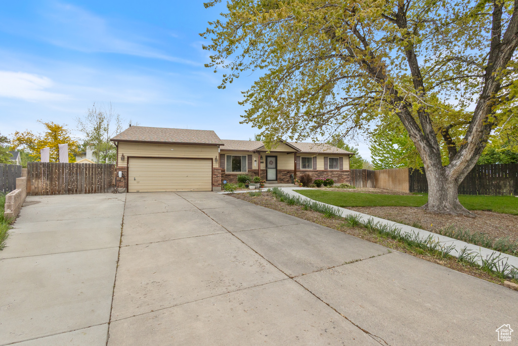 Ranch-style home with an attached garage, concrete driveway, and brick siding