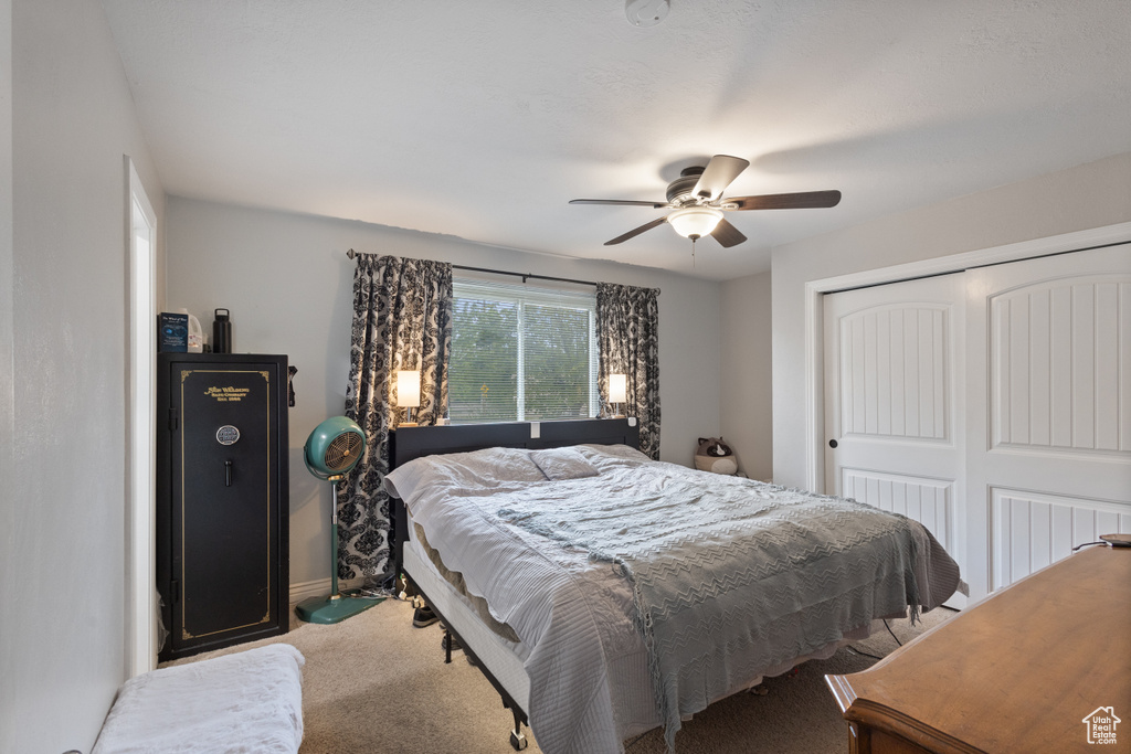 Bedroom with a closet, carpet floors, a ceiling fan, and baseboards