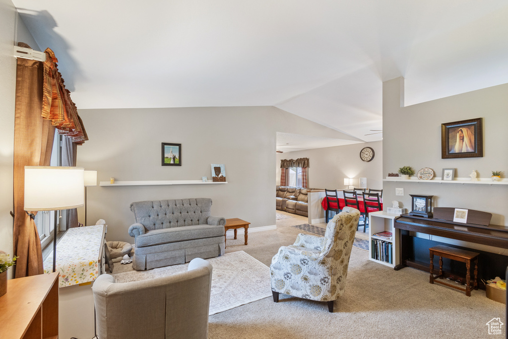 Carpeted living area with lofted ceiling
