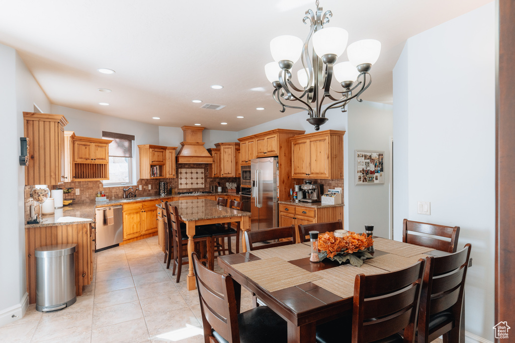 Dining space with a chandelier, light tile patterned flooring, and recessed lighting