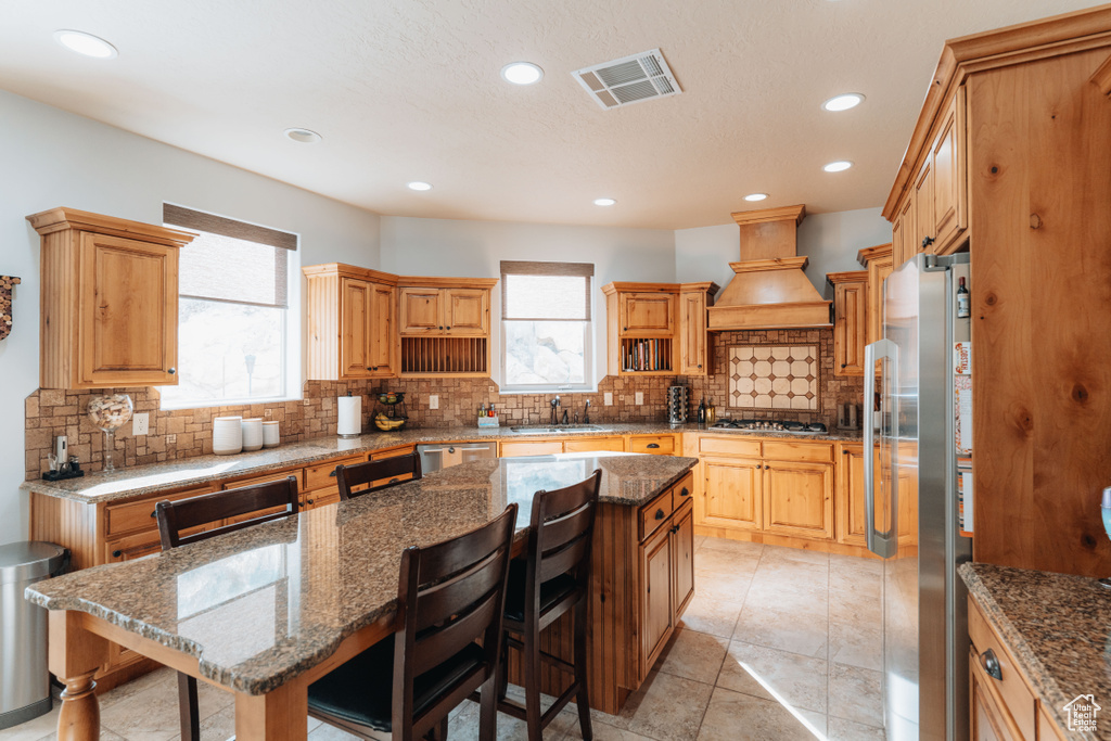 Kitchen with appliances with stainless steel finishes, healthy amount of natural light, a sink, decorative backsplash, and recessed lighting
