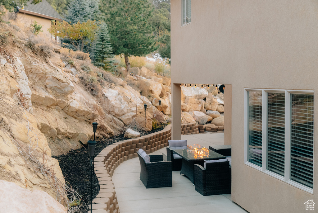 View of patio with an outdoor living space with a fire pit