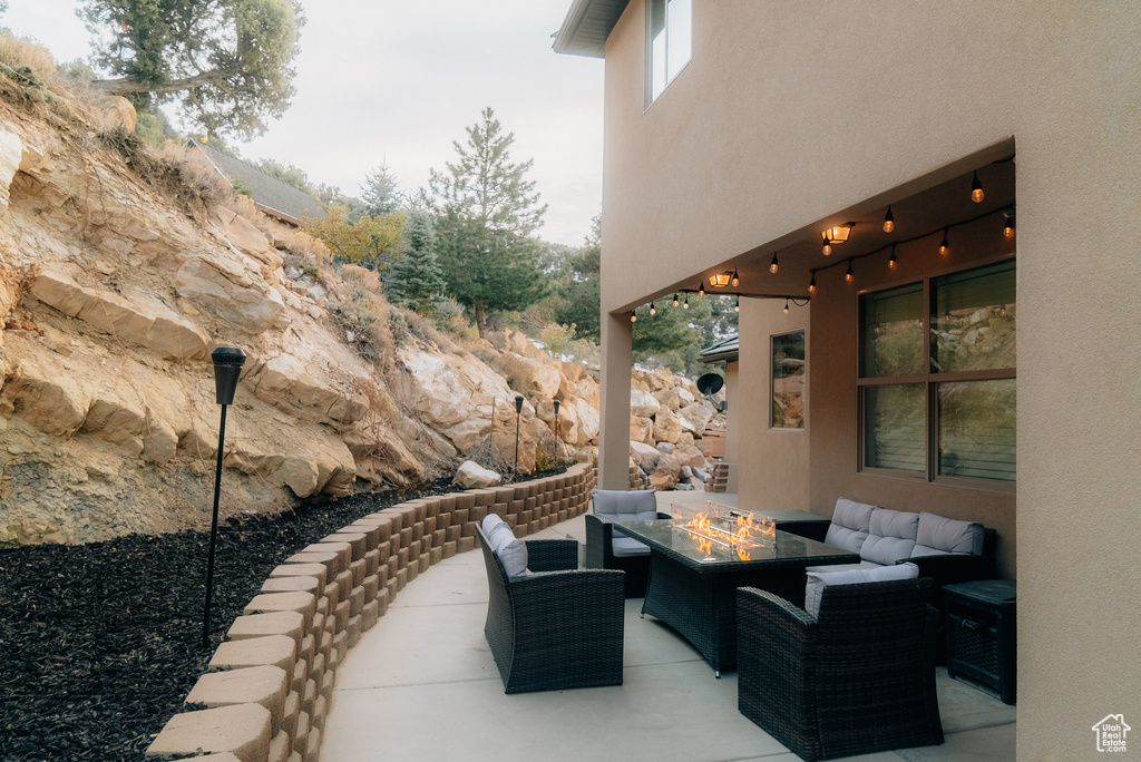 View of patio featuring an outdoor living space with a fire pit
