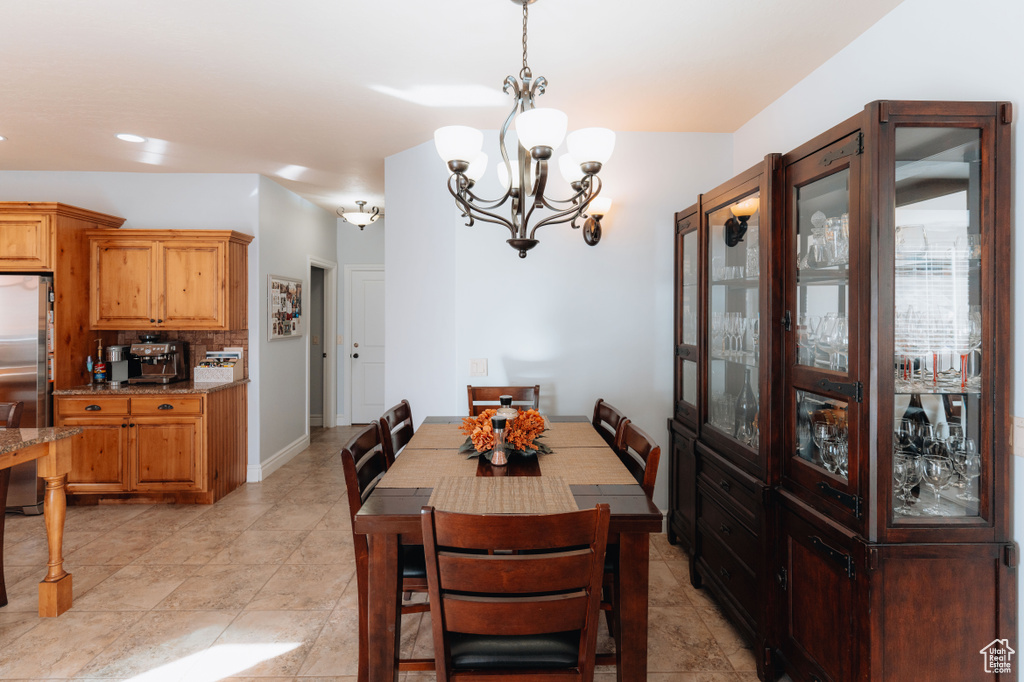 Dining space with a chandelier, recessed lighting, light tile patterned floors, and baseboards