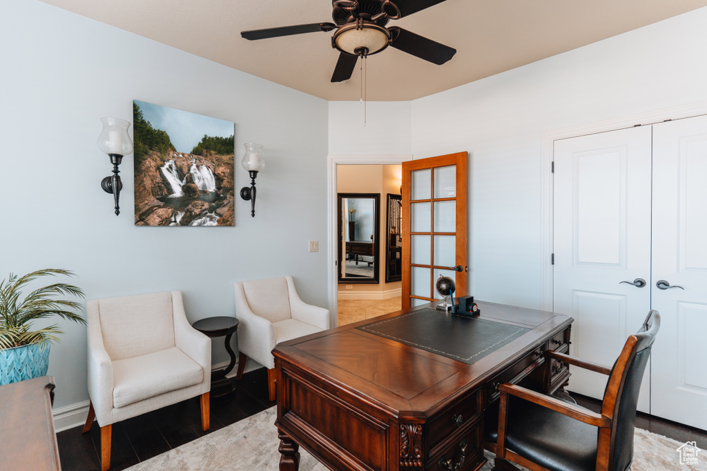 Home office with a ceiling fan, light wood-style flooring, and baseboards