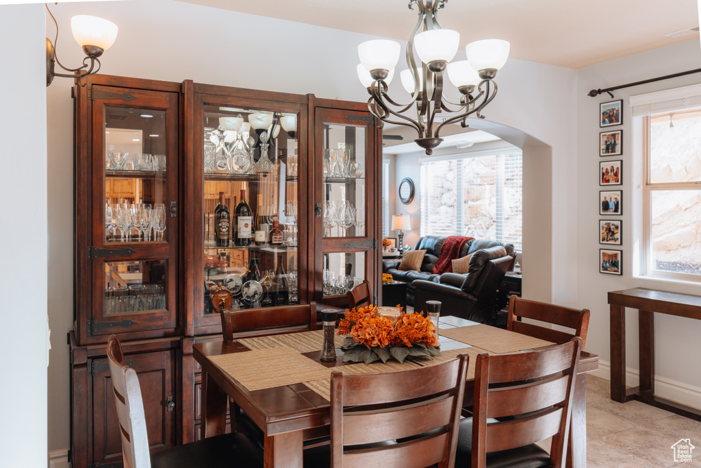 Dining area featuring a chandelier, arched walkways, and baseboards