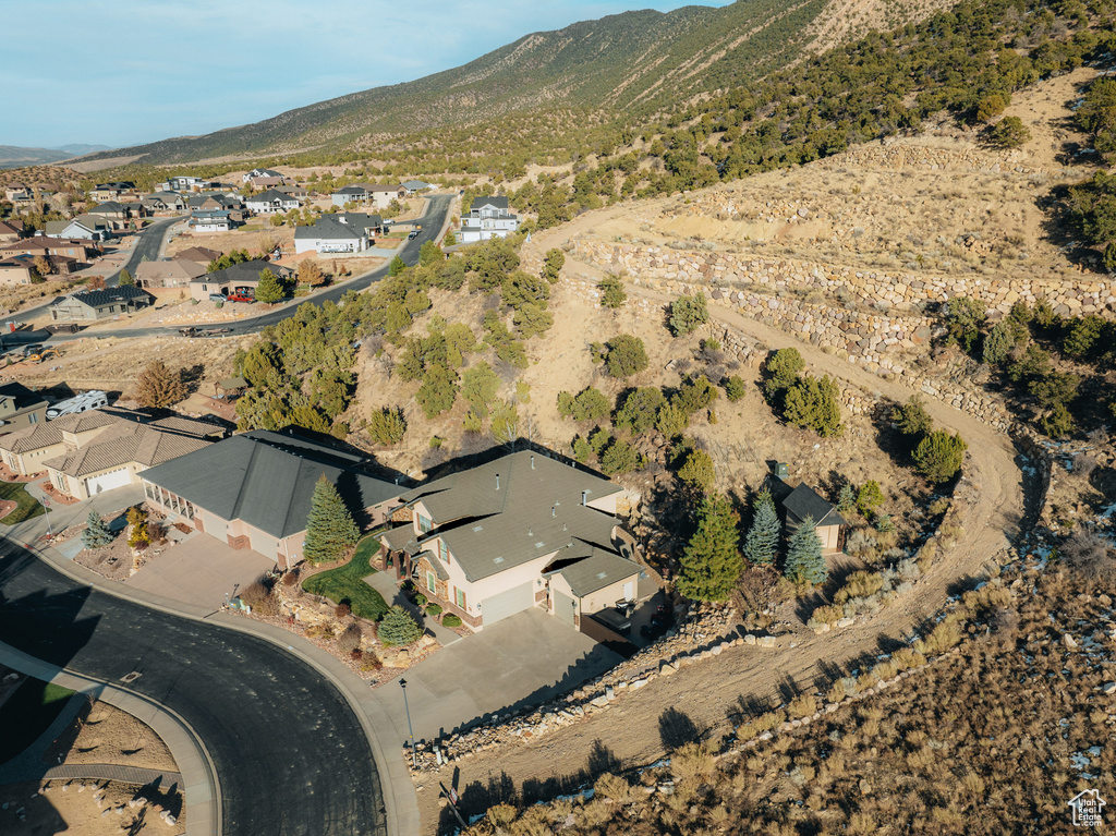 Aerial view of property and surrounding area featuring a mountainous background and nearby suburban area