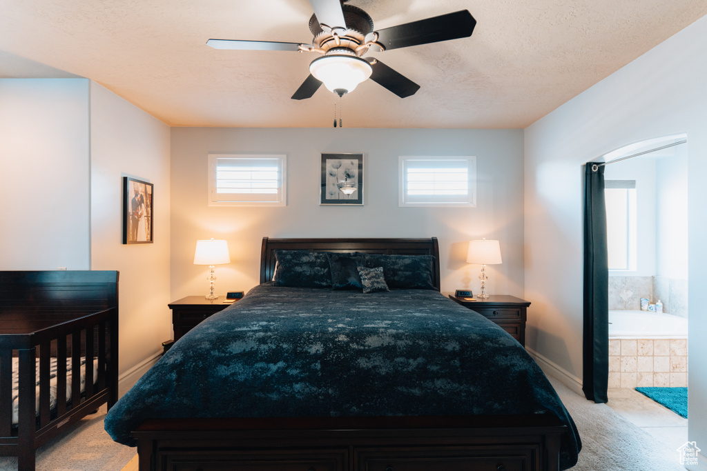 Bedroom with multiple windows, light colored carpet, ceiling fan, and baseboards