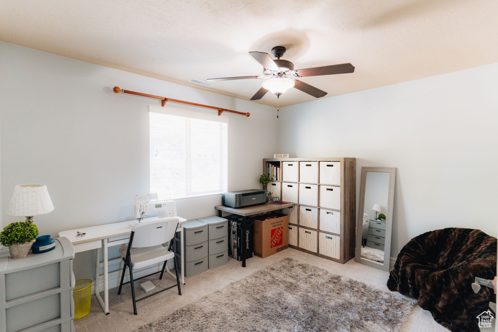 Office with ceiling fan and light carpet