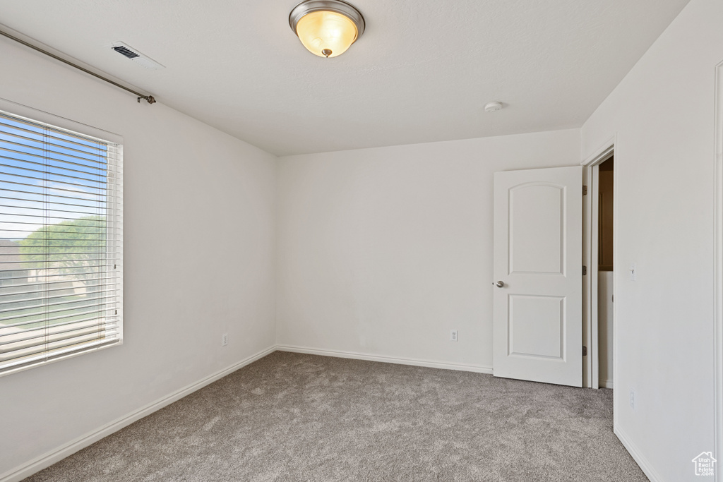 Spare room featuring carpet flooring and baseboards