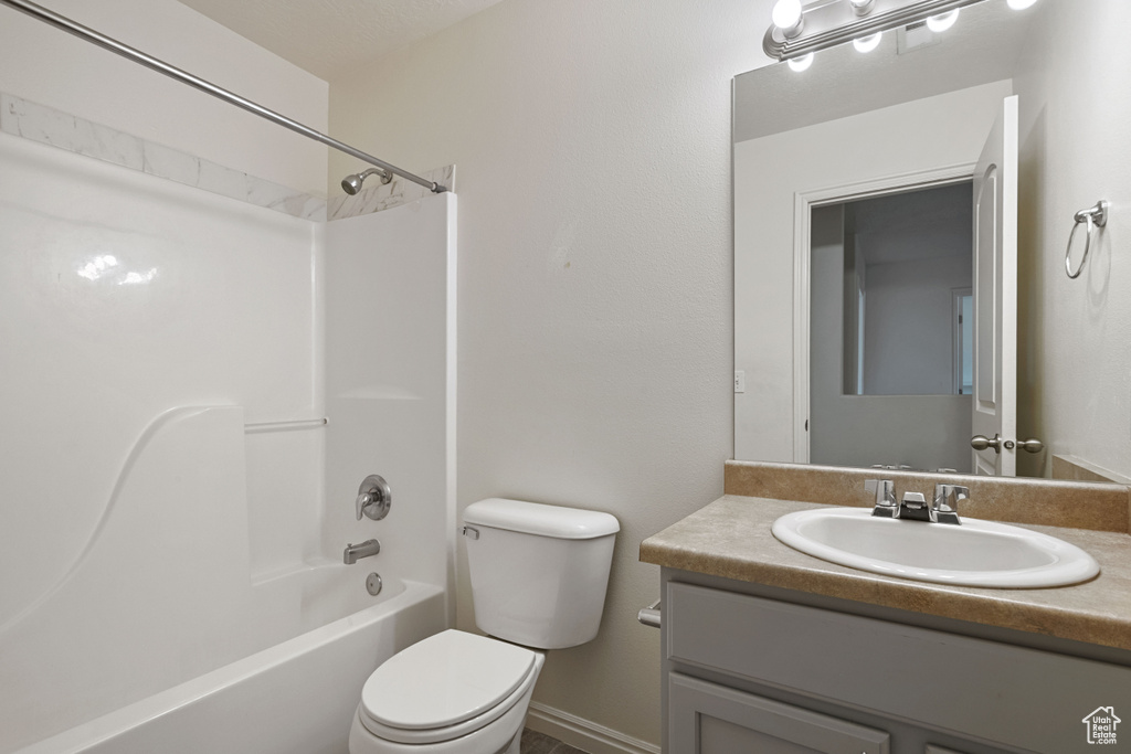 Bathroom featuring toilet, vanity, and  shower combination