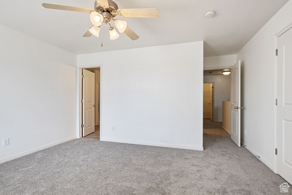 Unfurnished bedroom featuring carpet, baseboards, and ceiling fan