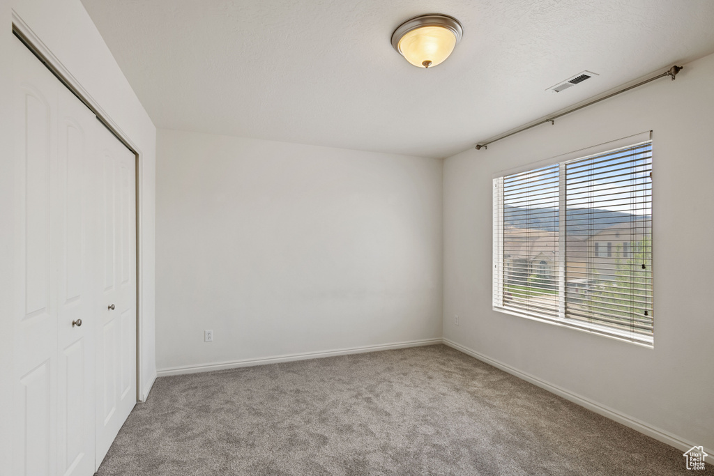 Unfurnished bedroom with a closet, carpet floors, and baseboards