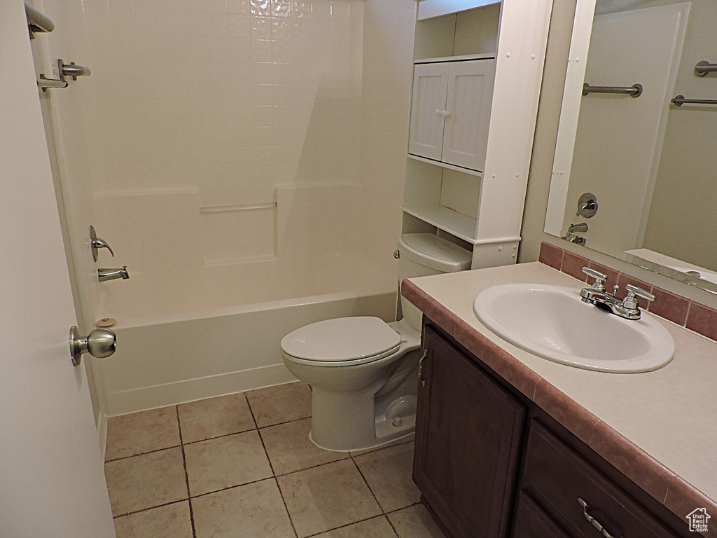 Bathroom featuring tile patterned floors, toilet, vanity, and bathing tub / shower combination