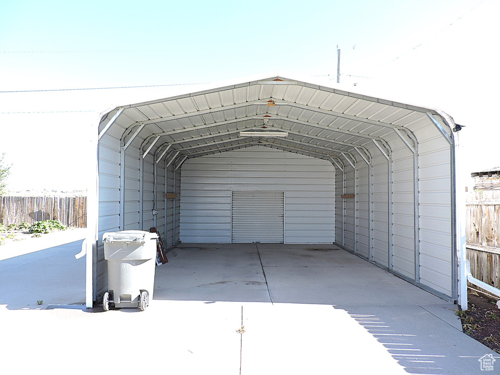 View of car parking with fence and a carport