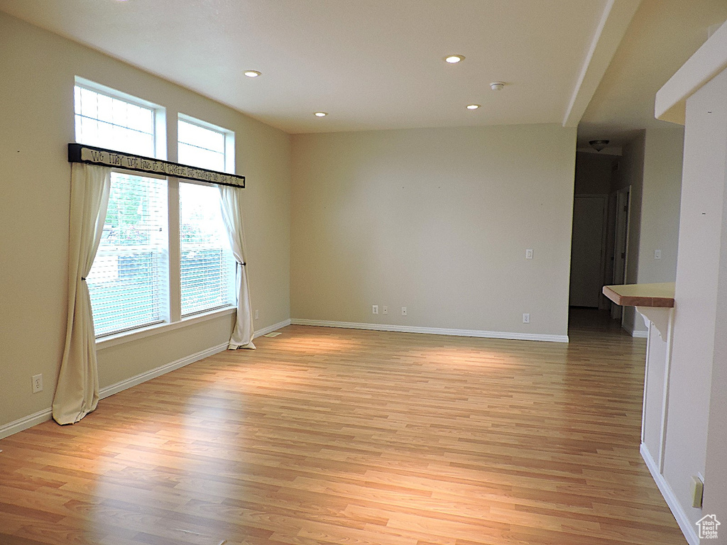 Unfurnished room with light wood finished floors, recessed lighting, and baseboards