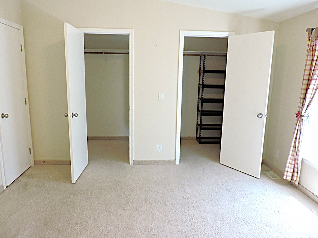 Unfurnished bedroom with multiple closets, carpet floors, and baseboards
