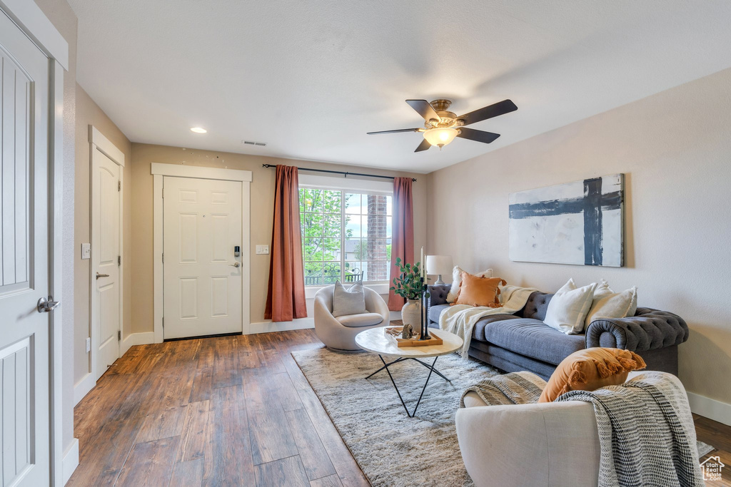 Living room with a ceiling fan, recessed lighting, baseboards, visible vents, and dark wood-type flooring