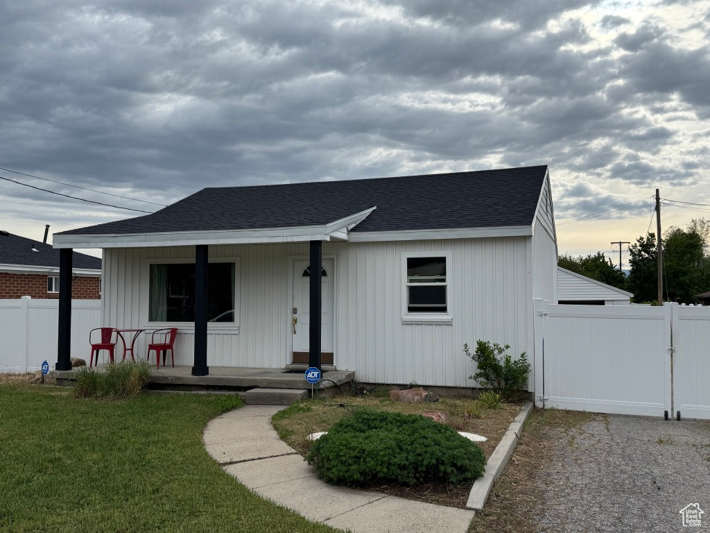 View of front of house featuring covered porch, a shingled roof, a gate, and board and batten siding