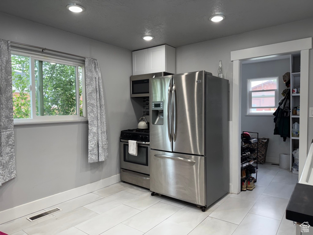 Kitchen featuring stainless steel appliances, white cabinets, and recessed lighting