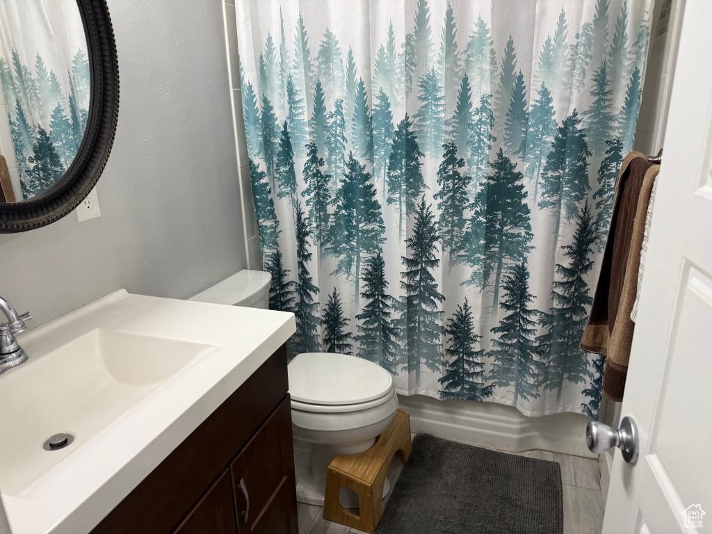 Bathroom featuring toilet, vanity, and shower / bath combo
