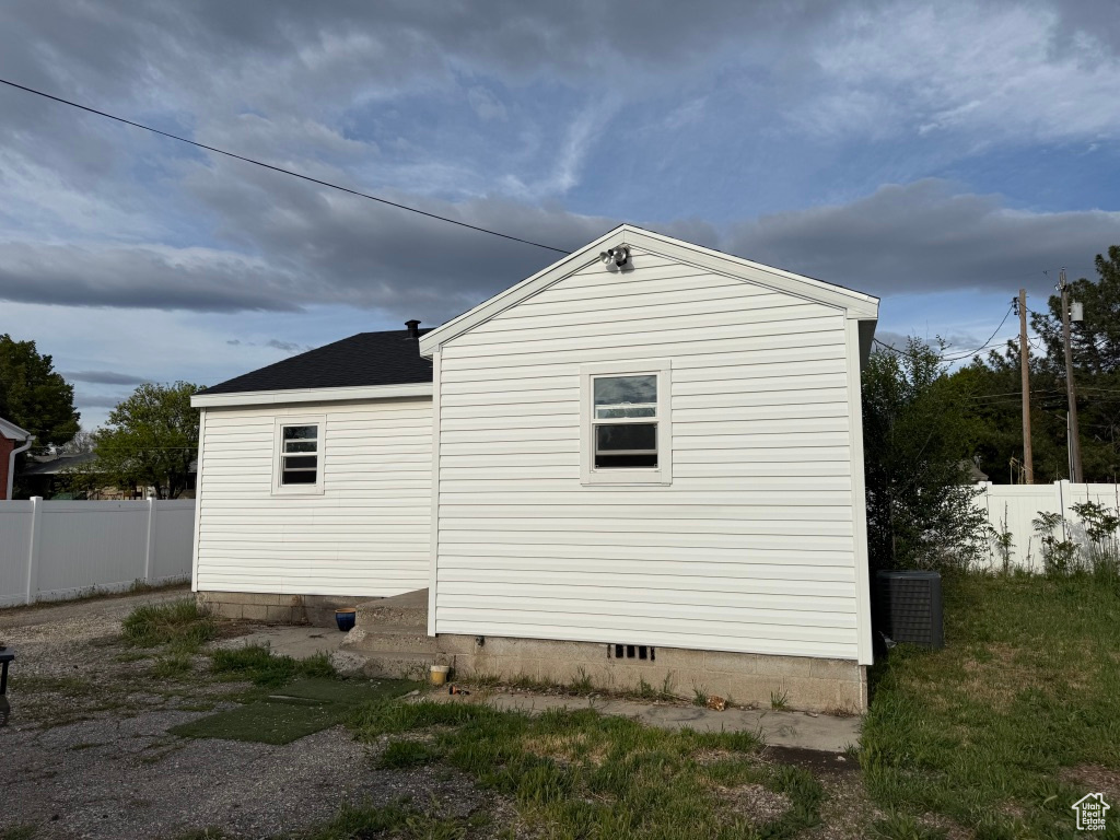 View of side of property featuring fence, crawl space, and cooling unit