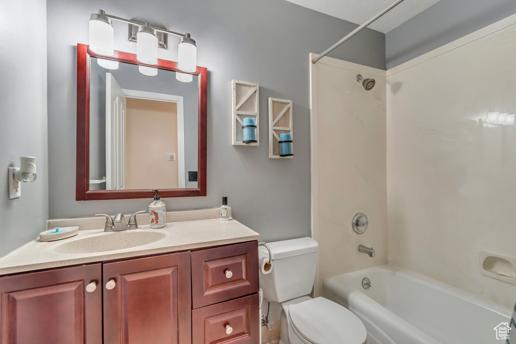 Bathroom with shower / bath combination, vanity, and toilet