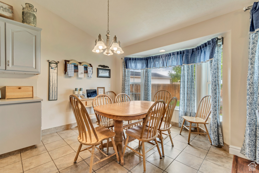 Dining room featuring light tile patterned floors, a chandelier, and baseboards