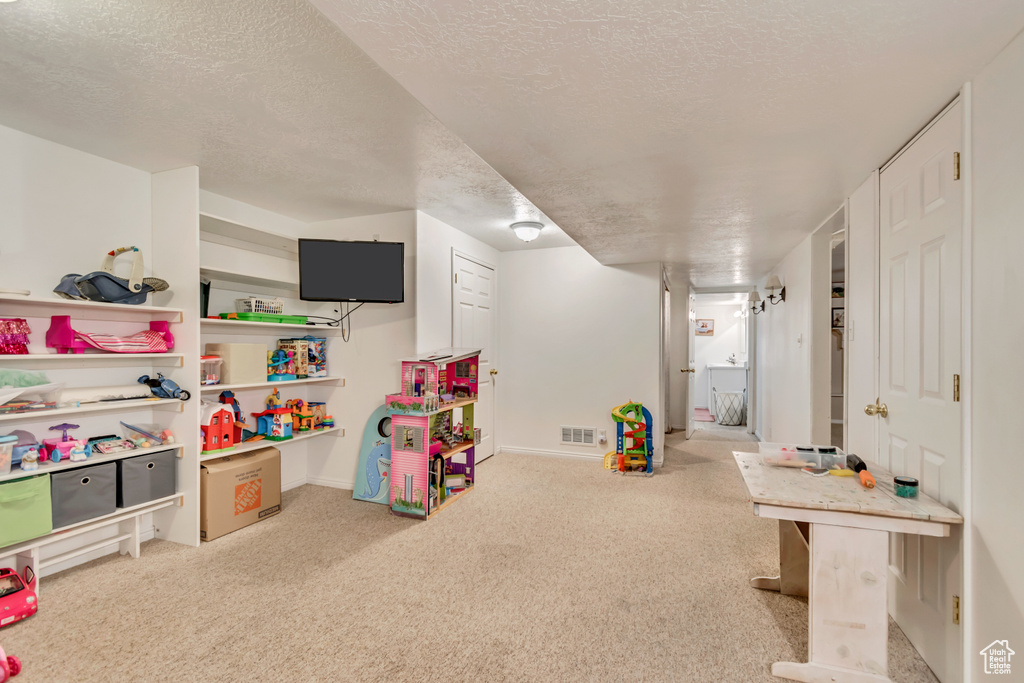 Playroom featuring carpet flooring, a textured ceiling, and baseboards