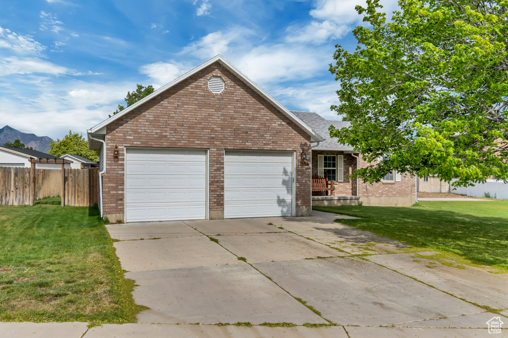 View of front facade with concrete driveway, brick siding, and an attached garage