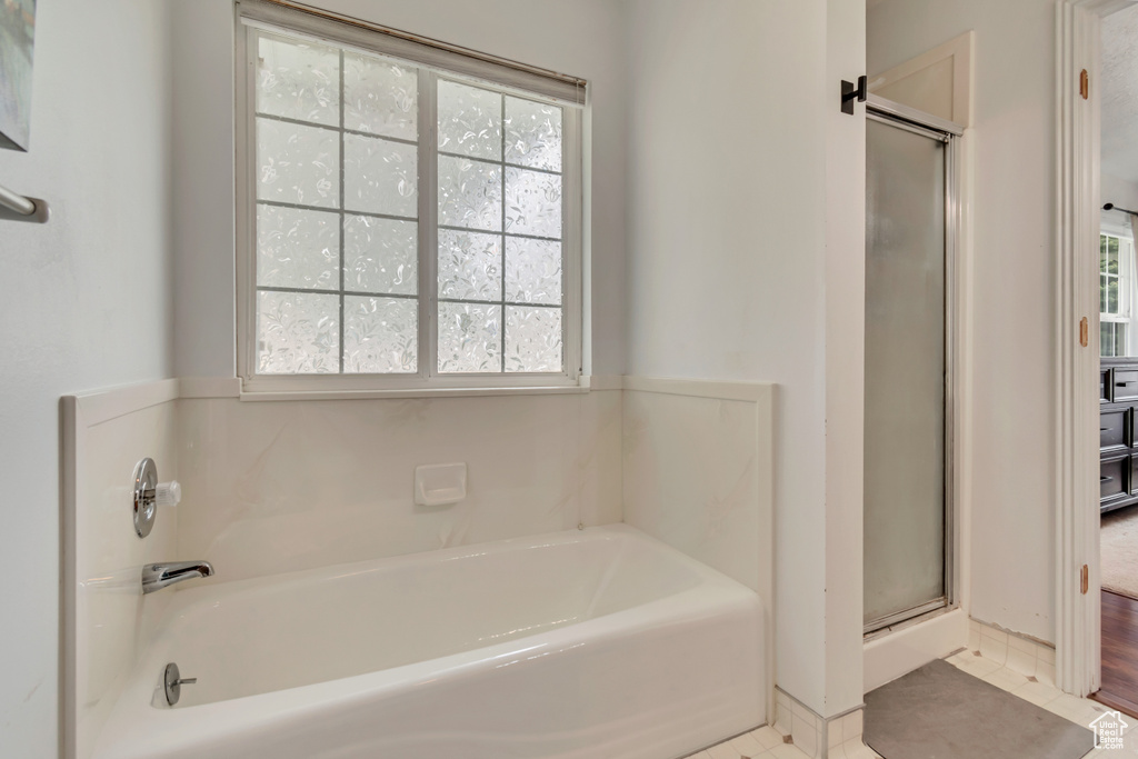 Full bathroom featuring a stall shower, a garden tub, and tile patterned floors