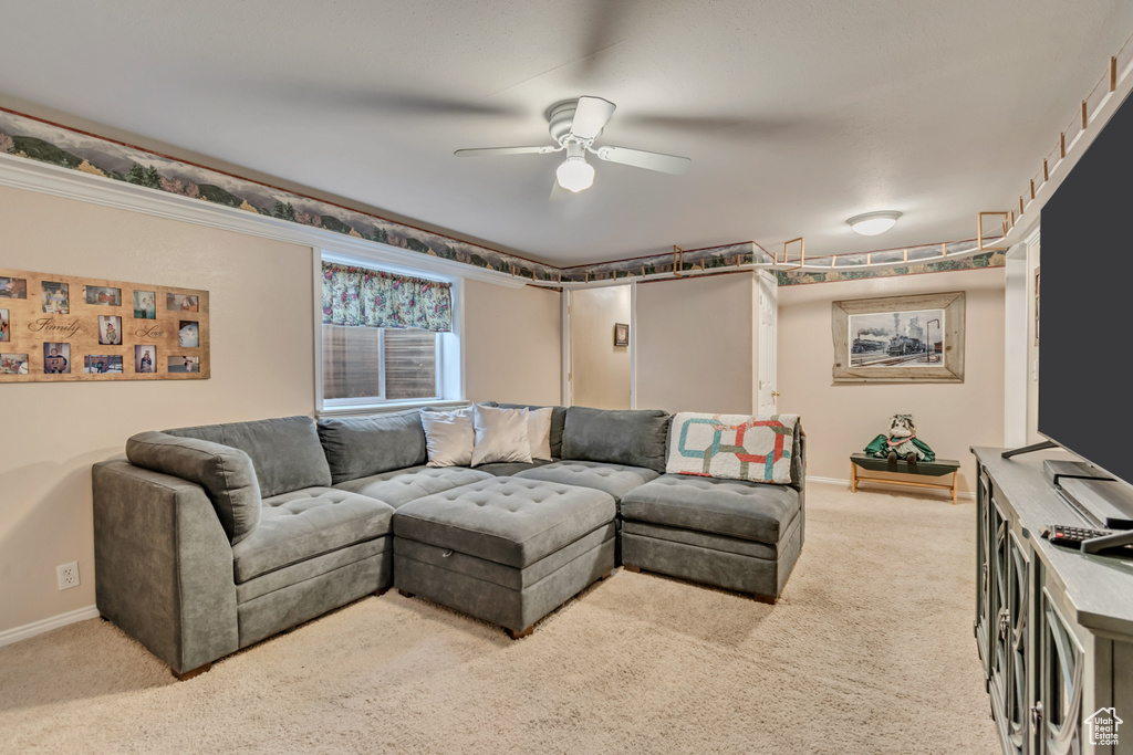 Living area with carpet floors, a ceiling fan, and baseboards