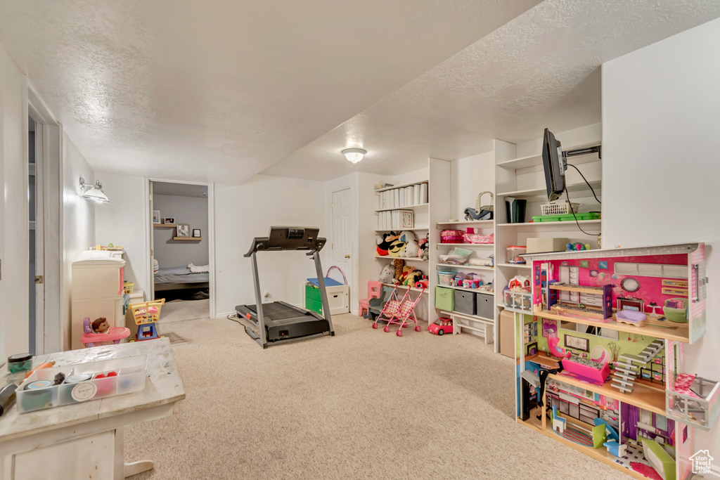Recreation room with carpet and a textured ceiling