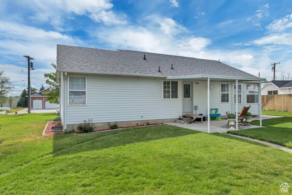 Back of property with a patio area, entry steps, and roof with shingles