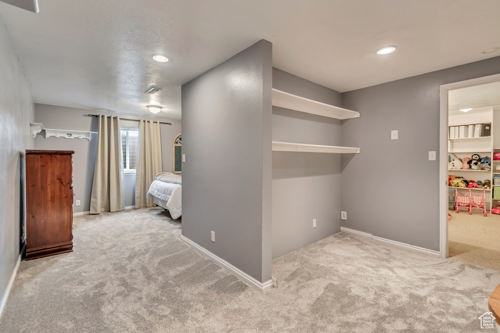 Unfurnished bedroom with carpet flooring, recessed lighting, baseboards, and a walk in closet