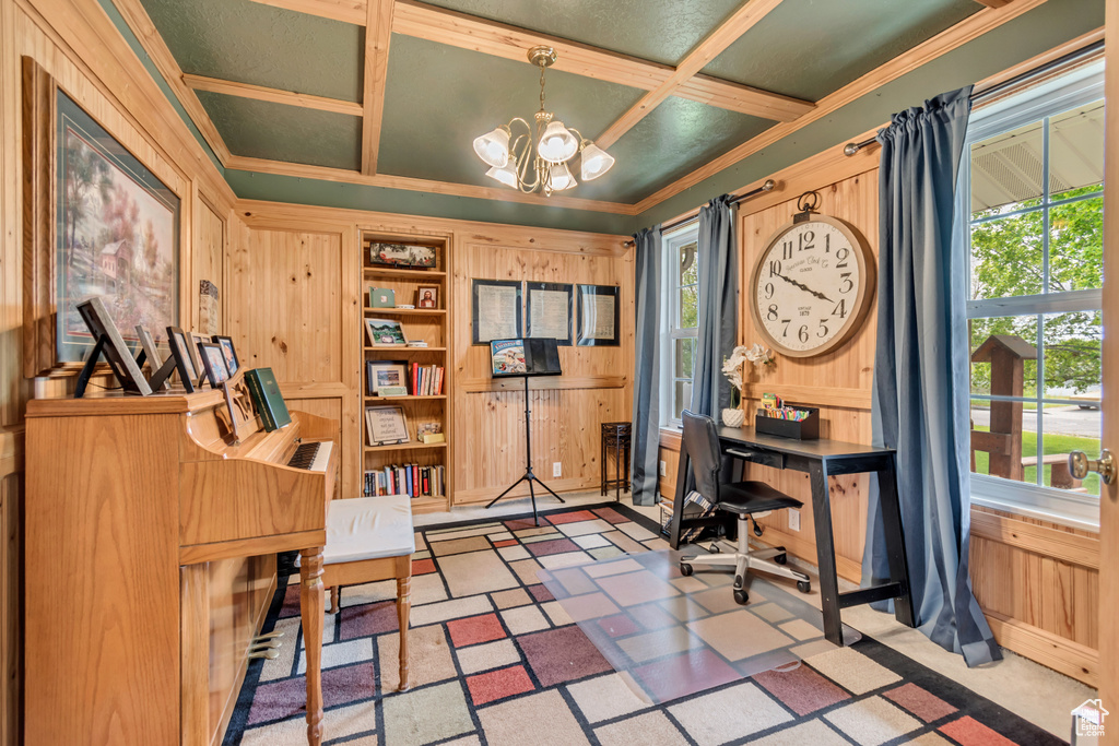 Office area featuring coffered ceiling, a chandelier, wooden walls, plenty of natural light, and crown molding