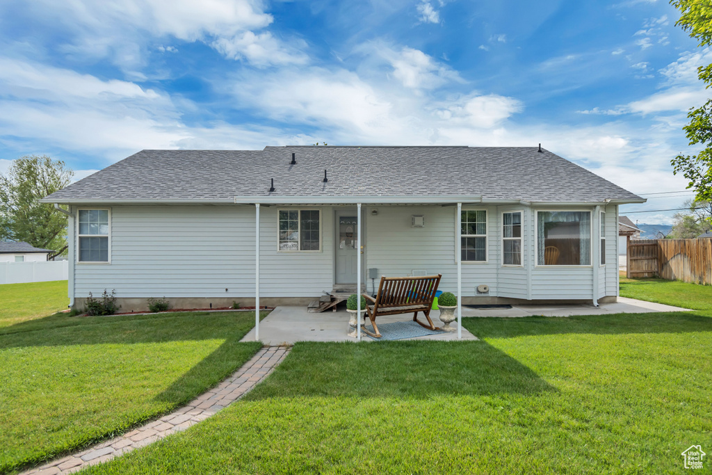 Rear view of property with a patio area and roof with shingles