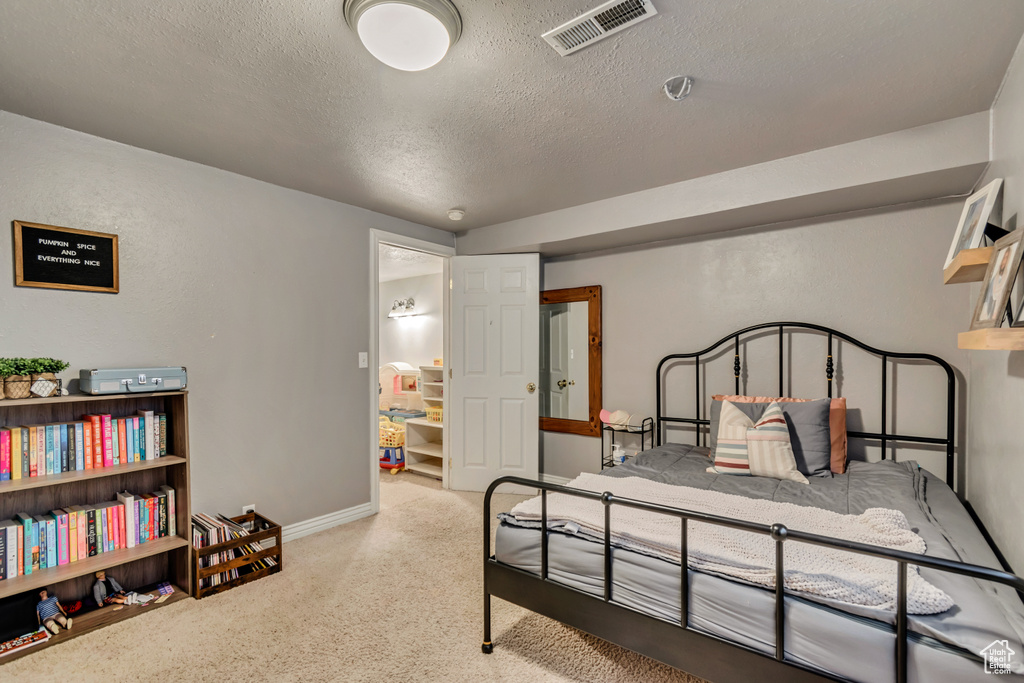 Bedroom featuring a textured ceiling, carpet flooring, and baseboards