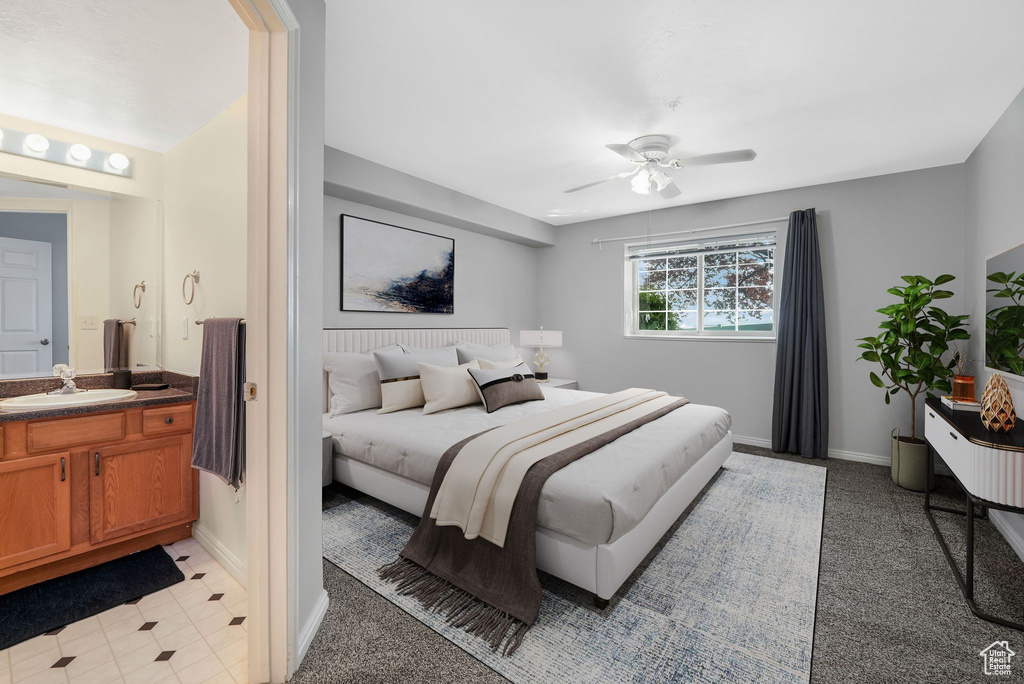 Bedroom featuring a sink, baseboards, light colored carpet, and ceiling fan