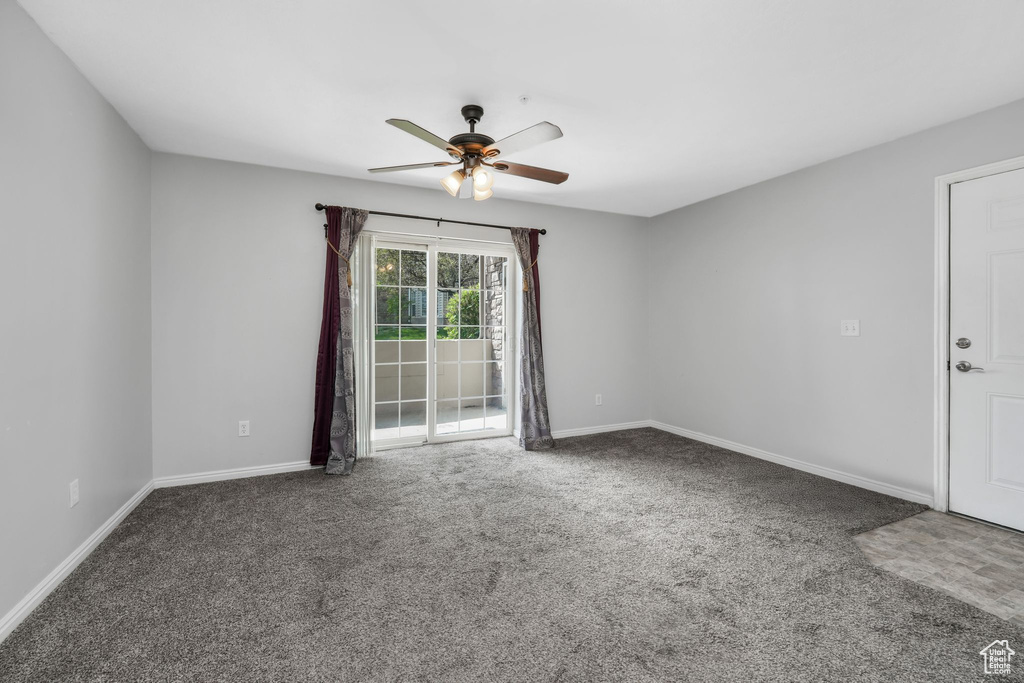 Unfurnished room with a ceiling fan, carpet, and baseboards