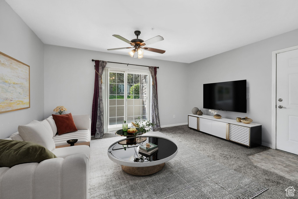 Living room with a ceiling fan, carpet flooring, and baseboards