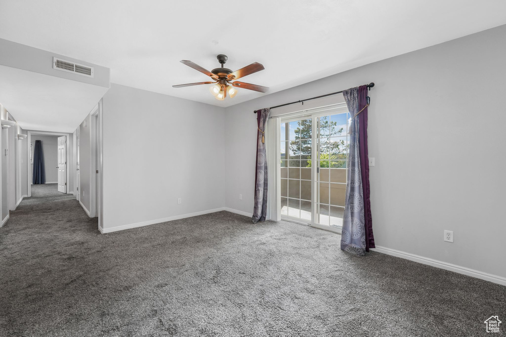 Spare room with a ceiling fan, carpet, and baseboards
