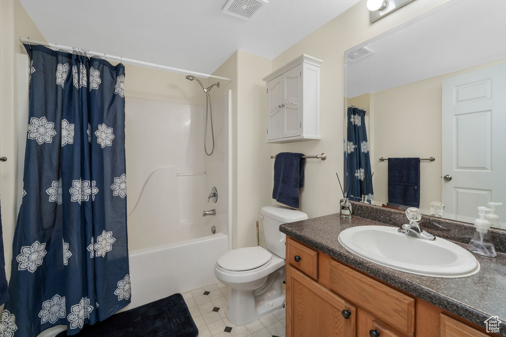Bathroom with toilet, vanity, and shower / bath combo
