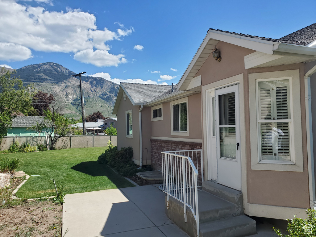 View of home\'s exterior with brick siding, a mountain view, stucco siding, and a patio area