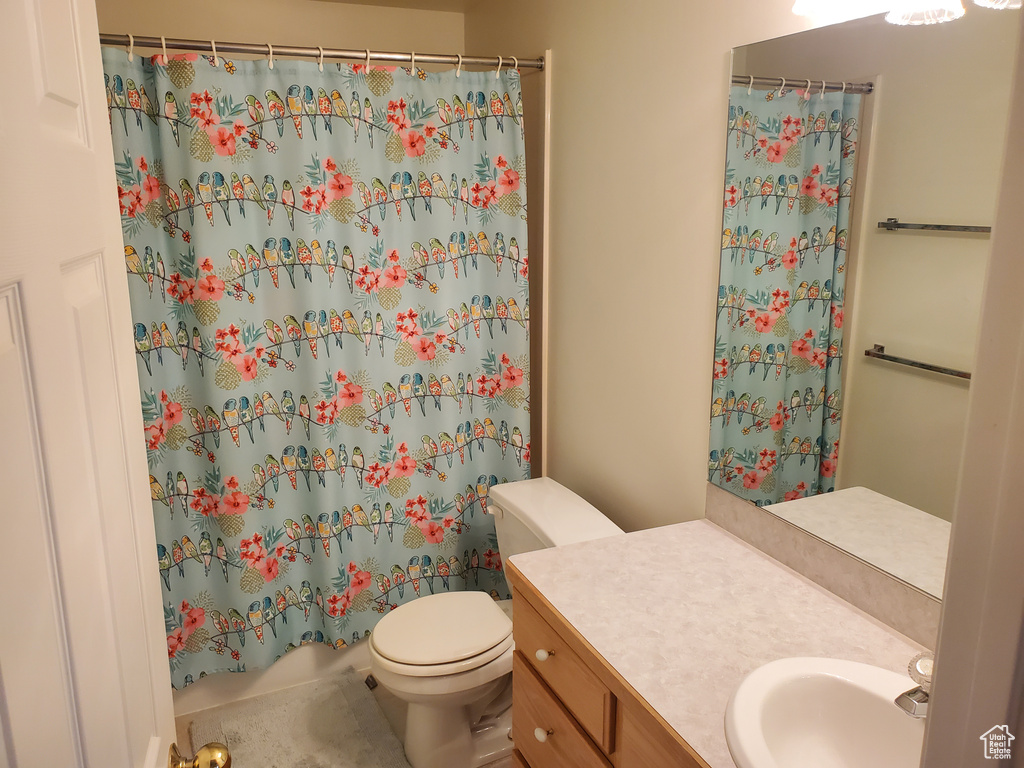 Full bath with toilet, vanity, and tile patterned floors